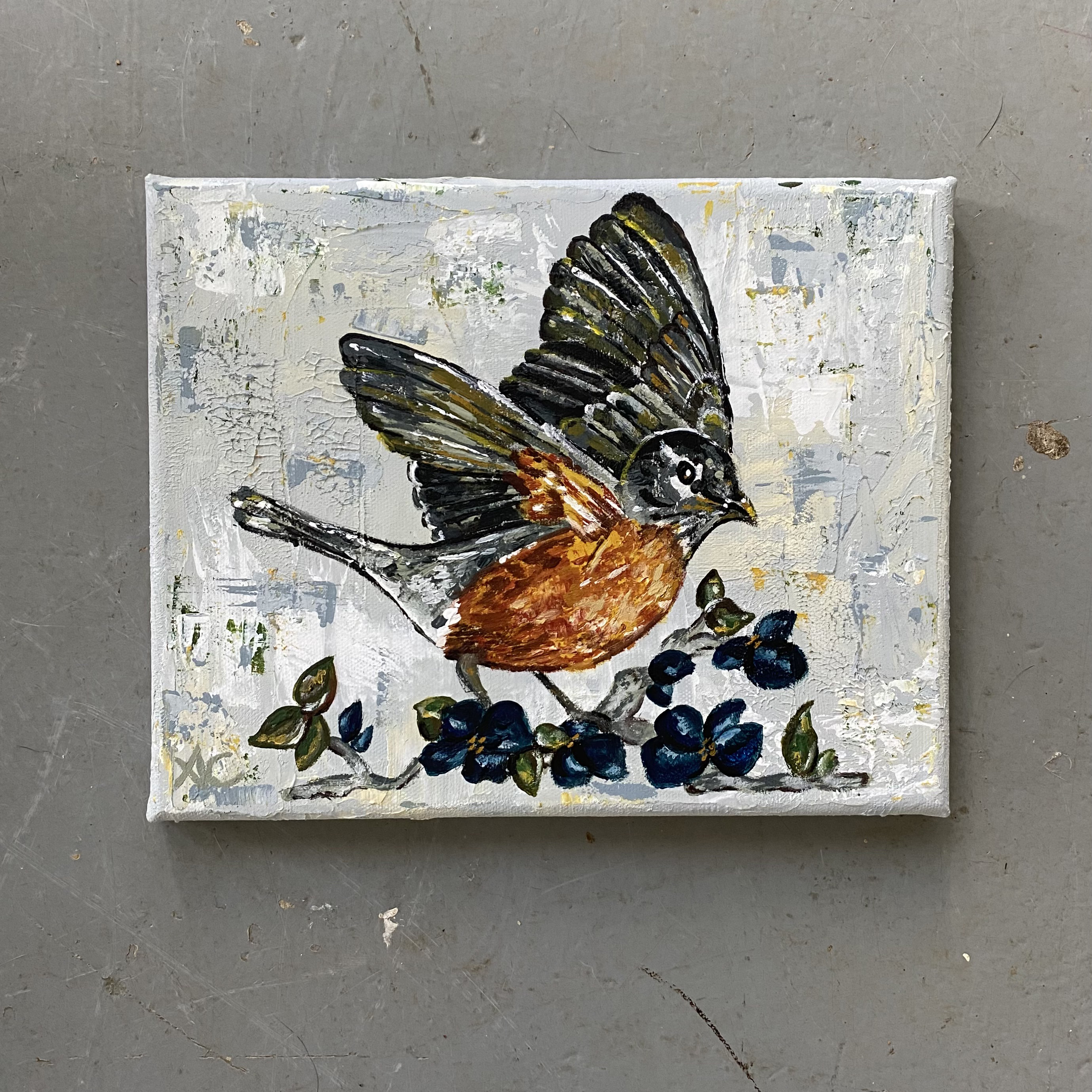 Small acrylic and gesso robin painting. Abstract style of bird on blue flowers, light blue gray background.